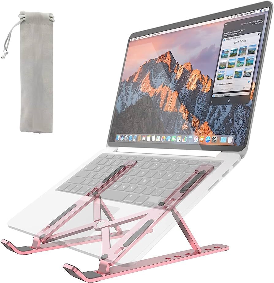 Pink laptop stand holding a laptop with a mountain-themed screen on a white background